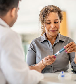 a woman with diabetes visits her doctor and receives a glp-1 medication, which she is inspecting
