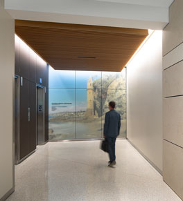a person walks by a mural of a local beach scene in one of the elevator bays at UCI Health Irvine