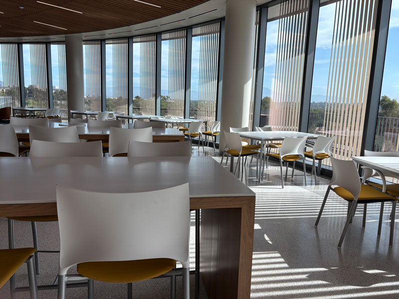 image of the dining area filled with natural light at the uci health irvine acute care hospital - white chairs and tables are made from safe easy to clean surfaces
