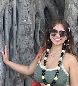 Alyssa Walls stands by a banyan tree in summer clothing, happy after curing hyperhidrosis.