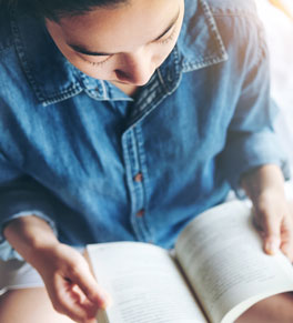 a woman going through cancer treatment reading a book to relax and find joy