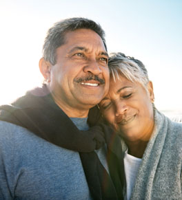 a man and his wife hug and look happy after the man has a kidney transplant