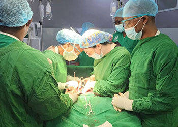 OB/GYN resident Courtney Fant and fellow Jennifer Draganchuk perform a radical hysterectomy under the supervision of Dr. Edgard Ndaboine as Bugando residents observe the procedure.