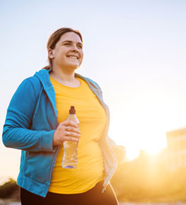 a woman walking outside as the sun rises 