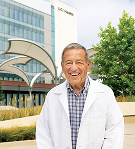 An elated Dr. Thomas Cesario, former dean of the UC Irvine School of Medicine, stands in front of UCI Health — Irvine, the new acute care hospital on the university campus that he and colleagues fought for more than 50 years to see built..