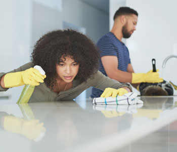 couple disinfecting their home with gloves