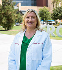 Christina Kirk, RN, standing outside UCI Douglas Hospital, has been named an oncology nurse champion.