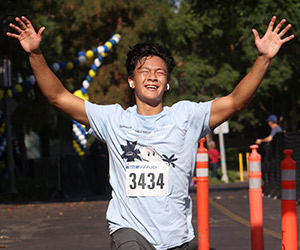 Runner reaches the finish line at the 2022 UCI Anti-Cancer Challenge.
