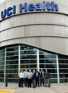 UCI Health team lead by Joe Brothman stands in front of medical center's facilities plant.