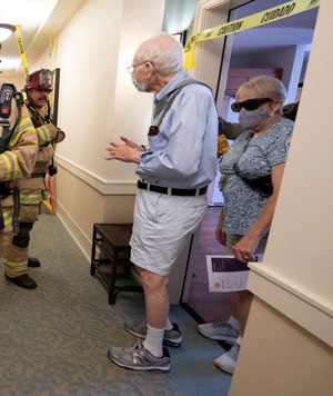 Anaheim first responders leading two senior residents to safety.