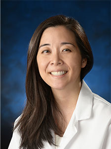 Connie M. Rhee, MD, photographed in white lab coat sitting in front of blue background.