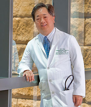 Dr. David Imagawa stands near a window in UCI Medical Center.