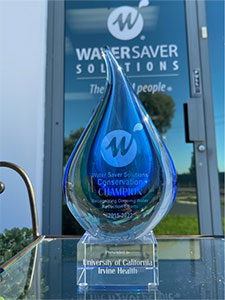UCI Health water conversation award shaped in the form of a water droplet displayed on glass tabletop.