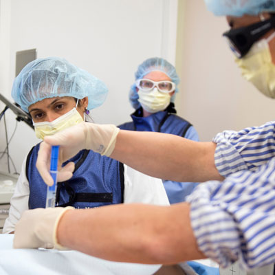 uci health anesthesiologist rakhi dayal leads a procedure in room with team members wearing scrubs and masks