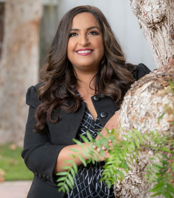 uci health child psychiatrist anju hurria comments in good morning america on study showing hospital parenting can lead to mental health problems; wearing jacket posing near tree