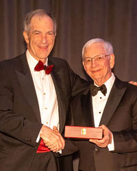 UCI Health urologist Dr. Ralph V. Clayman (left) holding the Keyes Medal, the highest honor for outstanding contributions to advance urology, with Dr. XXX, president of AAGUS.