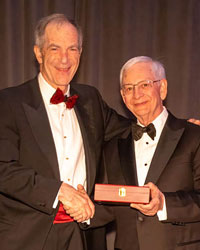 UCI Health urologist Dr. Ralph V. Clayman (left) holding the Keyes Medal, the highest honor for outstanding contributions to advance urology, with Dr. XXX, president of AAGUS. 