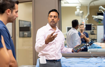 uci health emergency medicine physician bharath chakravarthy, center wearing white shirt, leads residents in a class; chakravarthy talked to the guardian about barriers to accessing naloxone
