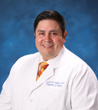 uci health bariatric surgeon marcelo hinojosa in white coat with blue background