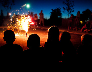 A crowd watches a fireworks display.