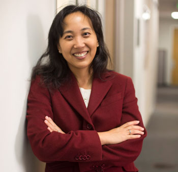 uci health infectious diseases expert dr susan huang wearing red blazer in hallway, smiling with arms crossed, huang has been awarded a 13.7 million federal grant to study six pathogens in nursing homes