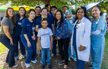 Caregivers from the UCI Health burn program with a young patient at the annual burn survivors picnic at UCI Medical Center.
