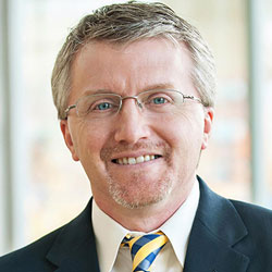 acupuncture researcher and susan samueli integrative health institute endowed chair richard harris wearing dark suit, tie, glasses and smiling outdoors