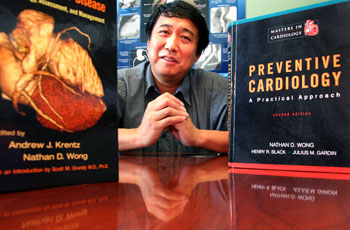 uci professor nathan wong smiling behind preventive cardiology textbook; wong is principal investigator of a study of wegovy, showing that it reduces heart attack, heart disease and stroke