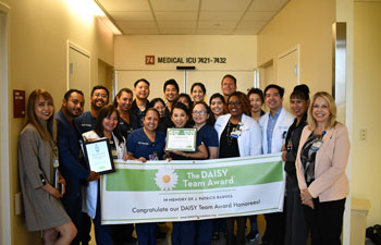 uci health medical intensive care unit team holding DAISY award sign and smiling