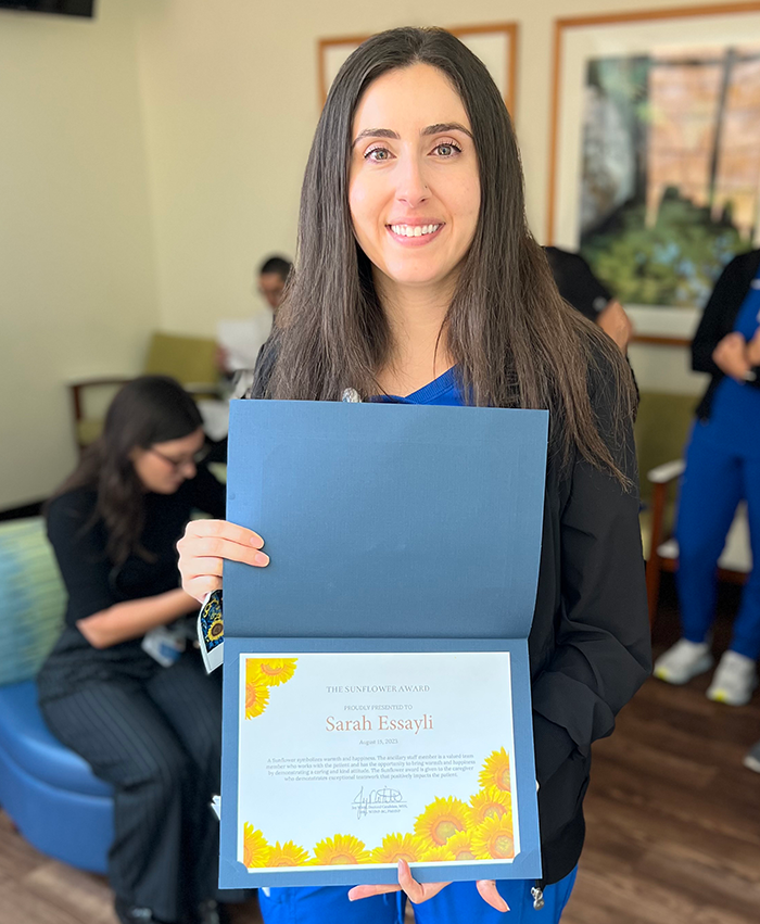 uci health nurse sarah essayli smiling and holding sunflower award
