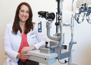 uci health gavin herbert eye institute ophthalmologist dr. marjam farid wearing a white coat standing in an office with eye equipment