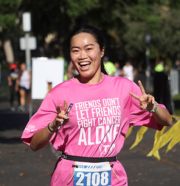 A woman is elated as she nears the finish line of the 2023 UCI Anti-Cancer Challenge.