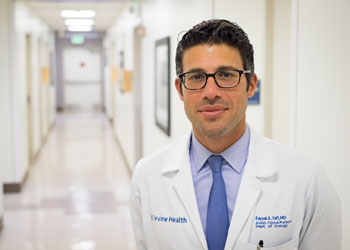 dr faysal yafi in a brightly lit hospital hallway wearing glasses and a white coat