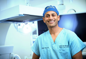 uci health urologist and kidney stone expert dr. roshan patel in an operating room wearing blue scrubs