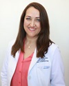 uci health ophthalmologist dr. marjan farid indoors wearing a white coat and orange top