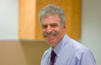 uci health pediatrician dan cooper in an office wearing a blue shirt and dark tie, smiling
