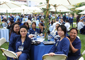 four uci health coworkers gather at a table outside for a photo at the uci health hospital week celebration at uci medical center in orange california