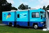 the uci health eye mobile for children on the side of a bus in white letters on a blue background with a cartoon image of a boy on the side