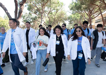 uci health medical students walk wearing white coats and blue shirts in support of national latino physician day at uc irvine school of medicine