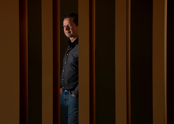 uci health gavin herbert eye institute researcher dr henry klassen is discovering new ways to use stem cells to repair the retina, offering new hope for people suffering from retinitis pigmentosa and macular degeneration. He stands between pillars looking at the camera. 