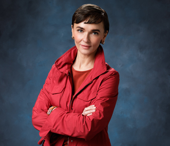 uci health chief strategy officer tatyana popkova wearing red in front of a blue studio background is the american heart association's orange county go red for women chair
