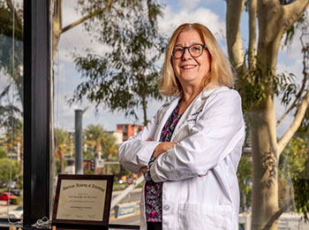 Parkinson's disease specialist Dr. Claire Henchcliffe in white coat with arms folded.