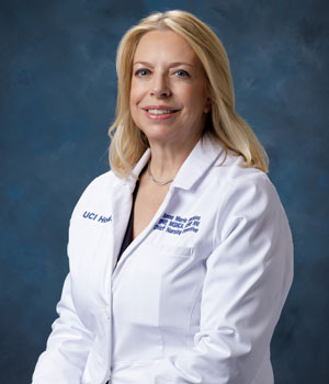 uci health chief nursing executive and senior vice president anne marie watkins in front of a blue studio background wearing a white coat