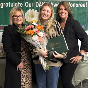 uci health daisy award winner emily mock accepting her award and holding a bouquet of flowers