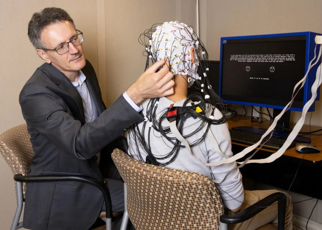 uc irvine researcher diego pizzagalli phd using a cap with electrodes on a research study participant