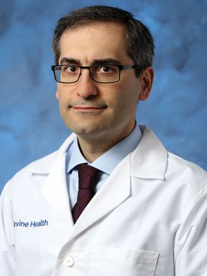 uci health neurologist dr s ahmad sajjadi wearing a white coat in front of a blue studio background