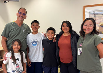 edther ocampo, center, his brother dominic, mom cynthia and younger sister reunite with uci health trauma surgeon dr. michael lekawa and his nurse
