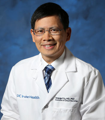 uci health neurologist dr wengui yu wearing a white coat in front of a blue studio background