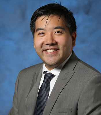 uci health autism and neurodevelopmental center medical director peter chung wearing a suit with a blue background