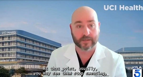 uci health emergency medicine physician dr ryan gibney wearing a white coat speaking to KTLA news with uci health -- irvine as a background